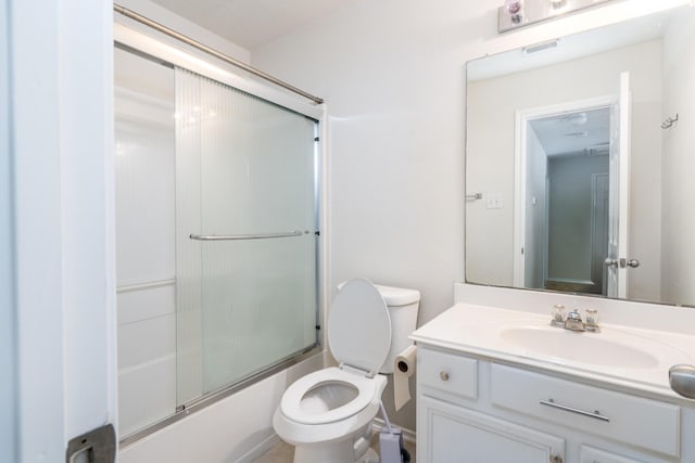 bathroom featuring visible vents, combined bath / shower with glass door, vanity, and toilet