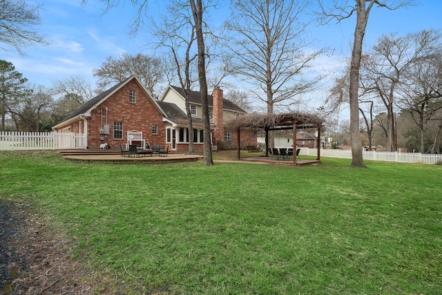 back of property featuring a yard, brick siding, a chimney, and fence