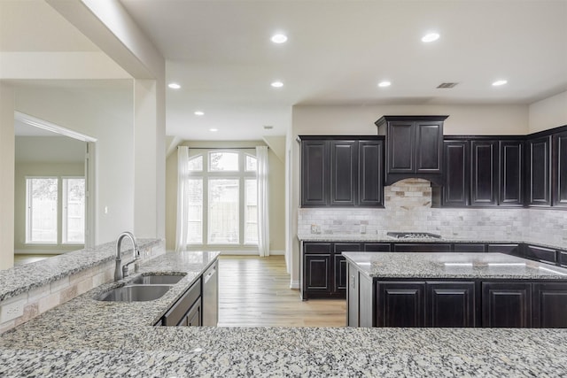4903 Cancun Hills Ct, Fulshear, TX 77441 - kitchen featuring stainless steel appliances, tasteful backsplash, light stone counters, light wood-style flooring, and recessed lighting