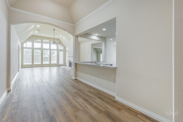 4903 Cancun Hills Ct, Fulshear, TX 77441 - unfurnished living room with arched walkways, ceiling fan, light wood-style floors, vaulted ceiling, and recessed lighting