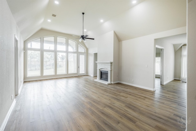 4903 Cancun Hills Ct, Fulshear, TX 77441 - unfurnished living room featuring plenty of natural light, a ceiling fan, a glass covered fireplace, wood finished floors, and recessed lighting