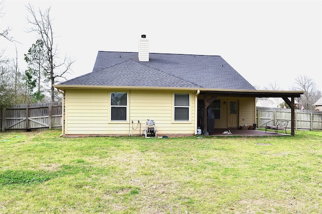 back of property featuring roof with shingles, a chimney, a lawn, a patio area, and fence