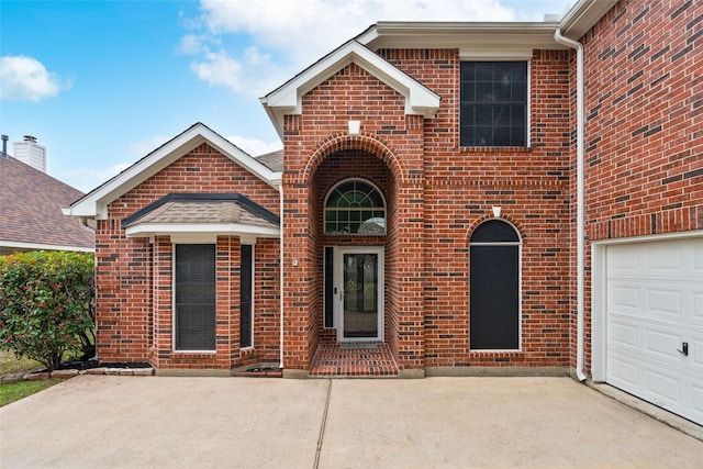 view of front of property featuring brick siding, concrete driveway, and a garage