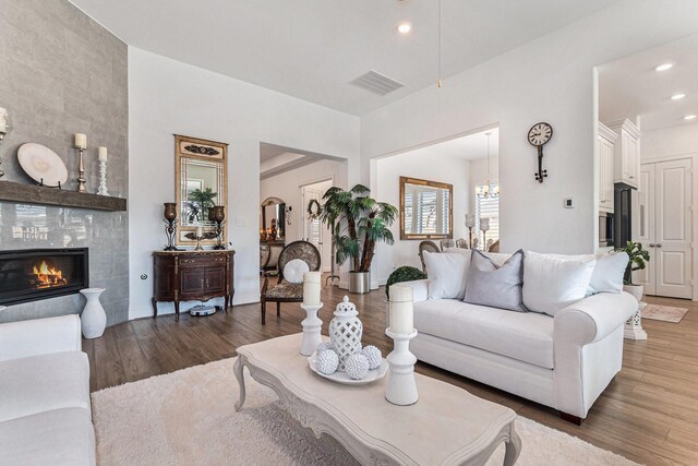 living area featuring a fireplace, recessed lighting, visible vents, wood finished floors, and baseboards