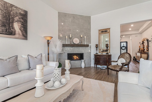 living room with recessed lighting, wood finished floors, and a tile fireplace