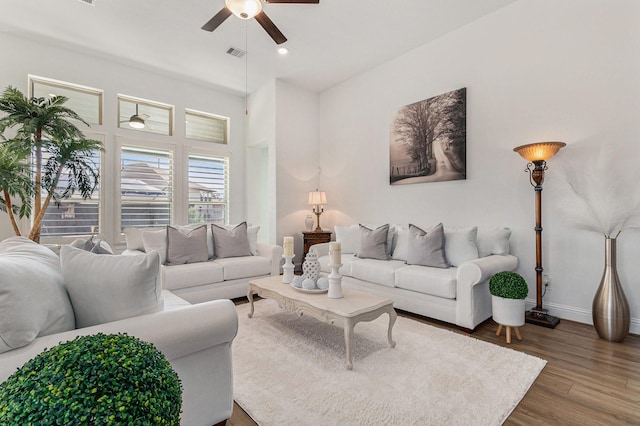 living room featuring visible vents, wood finished floors, a ceiling fan, and baseboards