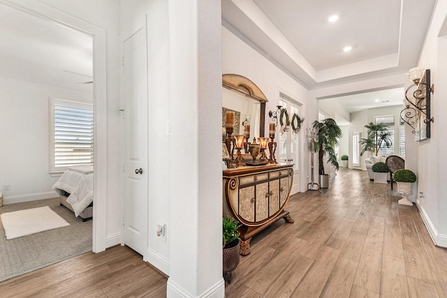 hall with plenty of natural light, light wood-style flooring, and baseboards