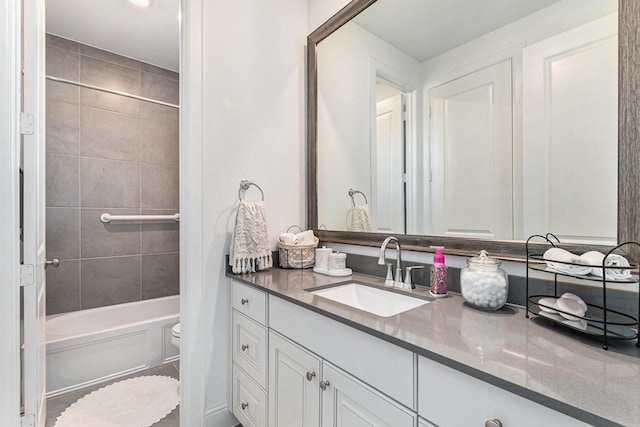 bathroom featuring toilet, shower / bathing tub combination, and vanity