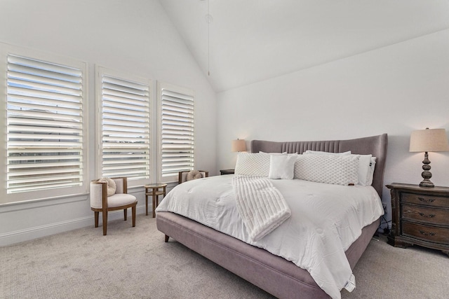 carpeted bedroom with lofted ceiling and baseboards