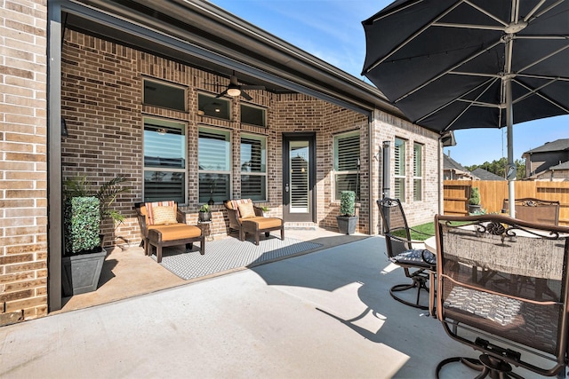 view of patio / terrace with outdoor dining area, fence, and ceiling fan