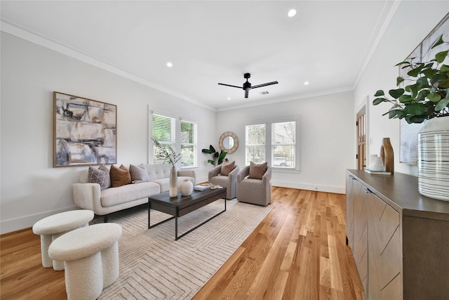 living room with ornamental molding, baseboards, and light wood finished floors