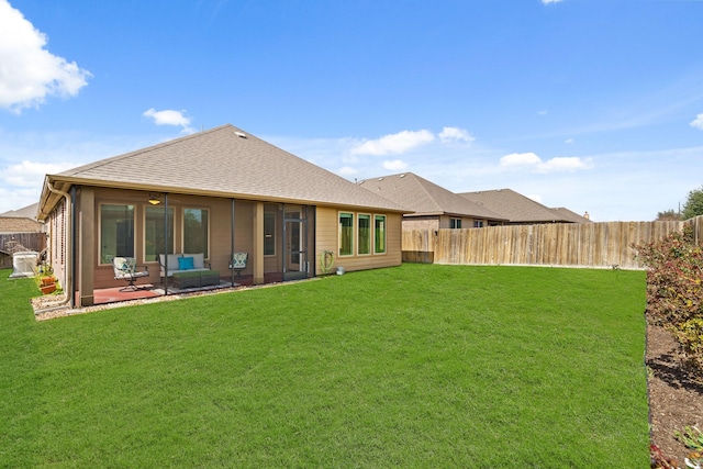 rear view of property with a fenced backyard, a shingled roof, a patio, and a yard