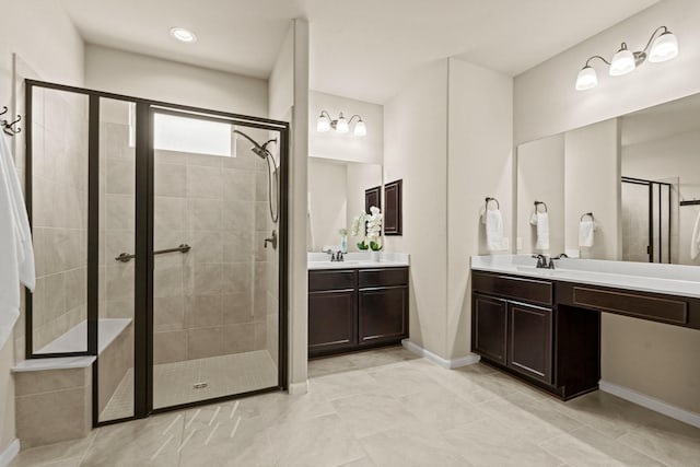 full bath featuring a stall shower, two vanities, and a sink