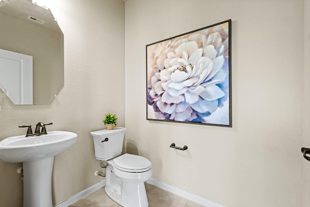 bathroom with tile patterned flooring, toilet, a sink, visible vents, and baseboards