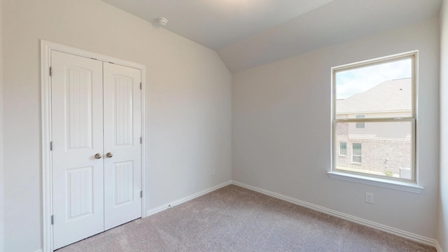 2011 Sunflower Ct, Sugar Land, TX 77498 - unfurnished bedroom featuring carpet flooring, multiple windows, a closet, baseboards, and lofted ceiling