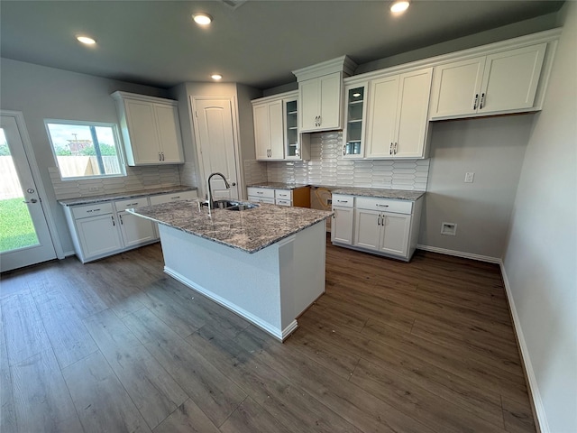 2011 Sunflower Ct, Sugar Land, TX 77498 - kitchen with white cabinets, backsplash, glass insert cabinets, an island with sink, and stone countertops