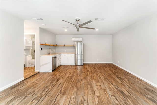 kitchen featuring visible vents, appliances with stainless steel finishes, wood finished floors, open shelves, and a sink