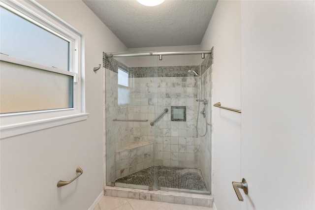 bathroom featuring baseboards, a shower stall, and a textured ceiling