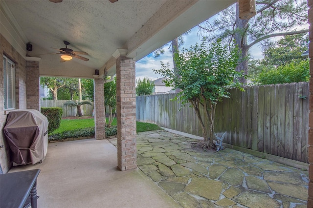 view of patio featuring grilling area, a fenced backyard, and a ceiling fan