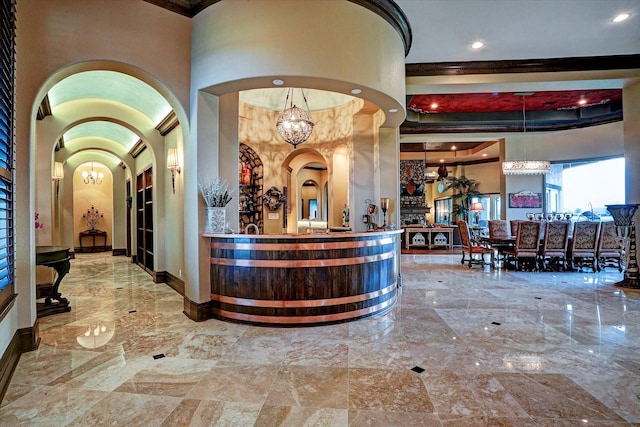 welcome area featuring arched walkways and an inviting chandelier