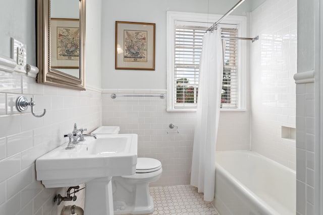 full bathroom featuring tile walls, shower / bathtub combination with curtain, toilet, wainscoting, and tile patterned floors