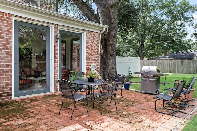 view of patio featuring outdoor dining space, fence, and area for grilling