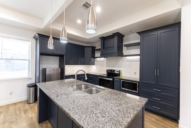 kitchen with light wood-style flooring, a sink, stainless steel appliances, decorative backsplash, and baseboards