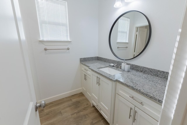 bathroom featuring vanity, baseboards, and wood finished floors