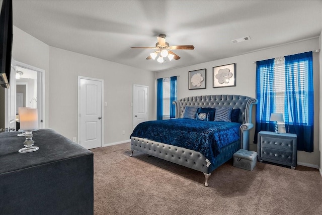 carpeted bedroom featuring a ceiling fan, visible vents, and baseboards