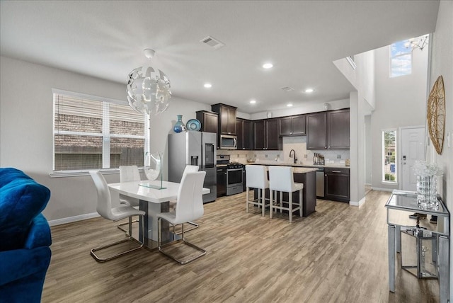 dining room featuring light wood finished floors, plenty of natural light, and visible vents