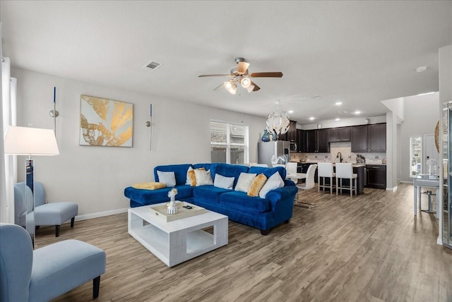 living area featuring recessed lighting, visible vents, light wood-style floors, ceiling fan, and baseboards