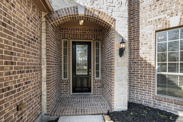 doorway to property featuring brick siding