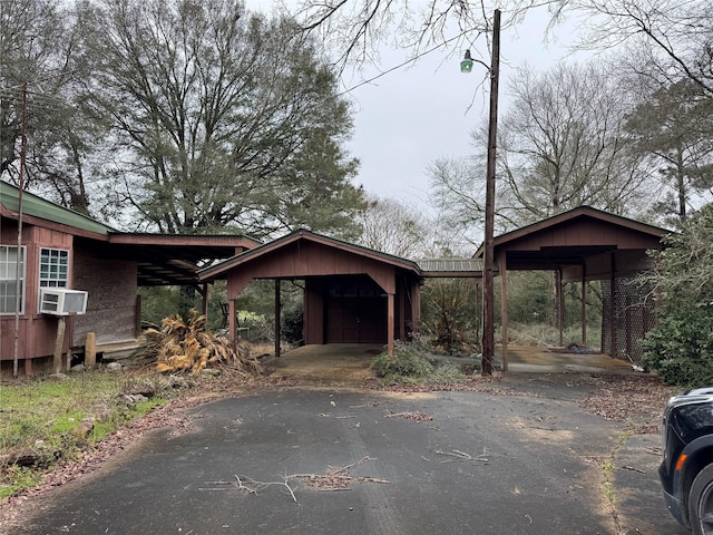 view of outbuilding with aphalt driveway, an outdoor structure, and cooling unit