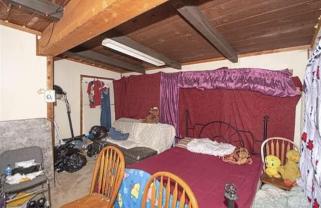 carpeted bedroom with wood ceiling and beamed ceiling