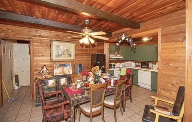 dining space with wooden ceiling, light tile patterned floors, beam ceiling, and wood walls