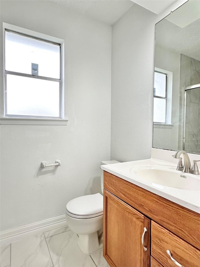 bathroom with a stall shower, baseboards, toilet, marble finish floor, and vanity