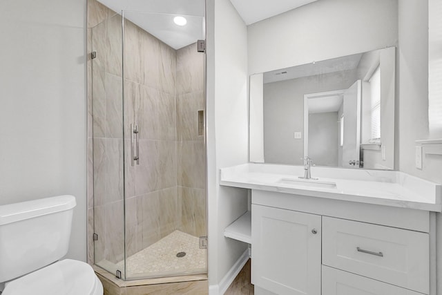 full bathroom with vanity, a shower stall, and toilet