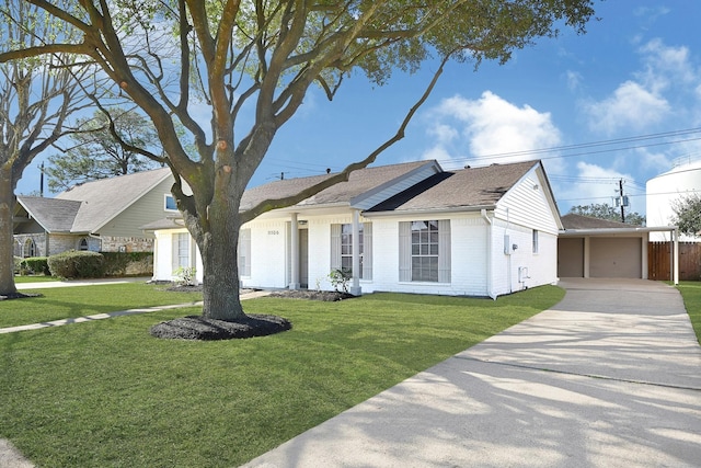 ranch-style house featuring an outbuilding, brick siding, a detached garage, roof with shingles, and a front lawn