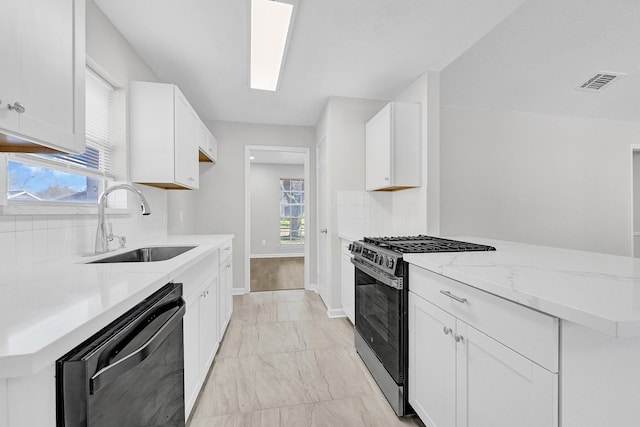 kitchen featuring black dishwasher, visible vents, gas stove, a sink, and light stone countertops