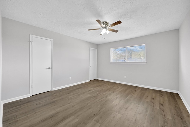 spare room featuring a ceiling fan, baseboards, and wood finished floors