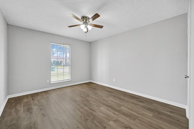 spare room featuring ceiling fan, a textured ceiling, baseboards, and wood finished floors