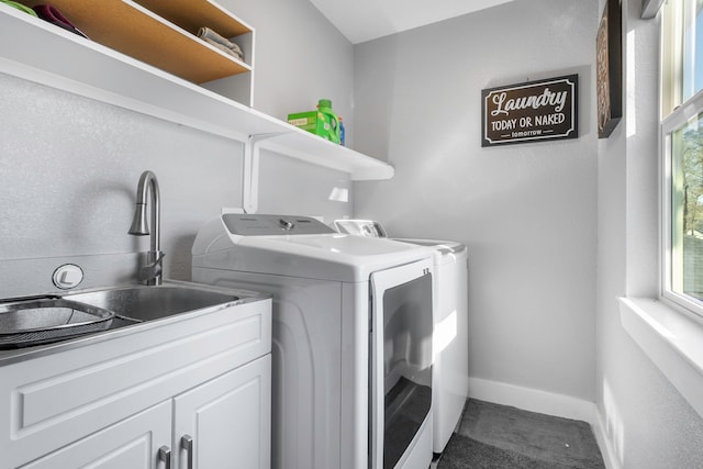 laundry room with plenty of natural light, baseboards, separate washer and dryer, and a sink