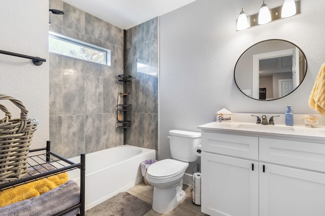 full bathroom with a textured wall, toilet, wood finished floors, bathtub / shower combination, and vanity