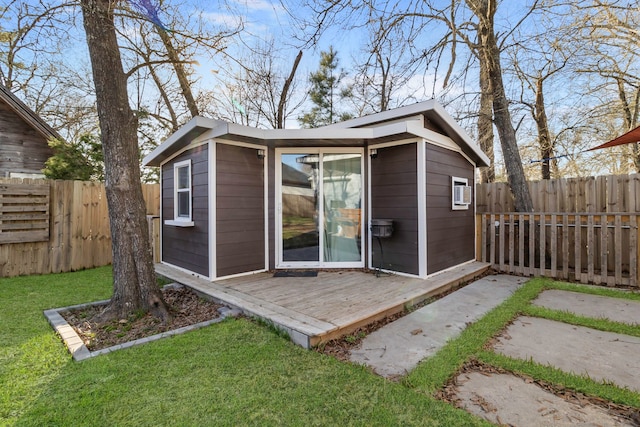 view of outdoor structure featuring a fenced backyard and an outbuilding