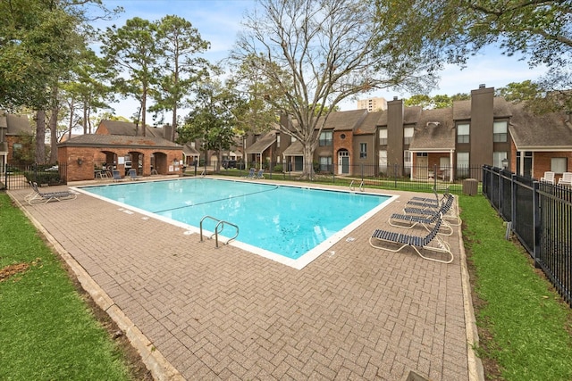 pool featuring a patio area, fence, and a residential view