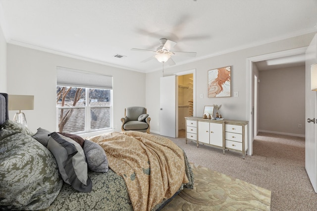 bedroom featuring visible vents, light colored carpet, ceiling fan, ornamental molding, and a walk in closet