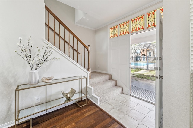 entryway with stairs, baseboards, crown molding, and wood finished floors