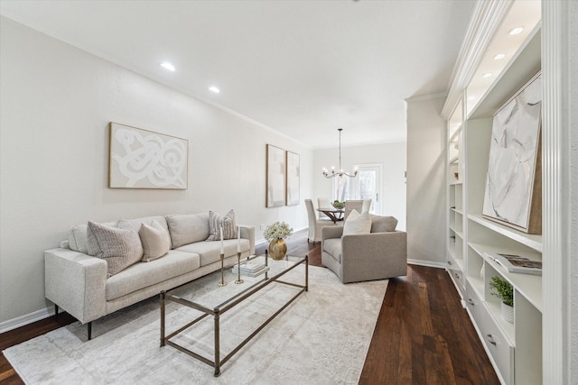 living area featuring baseboards, a chandelier, wood finished floors, and ornamental molding