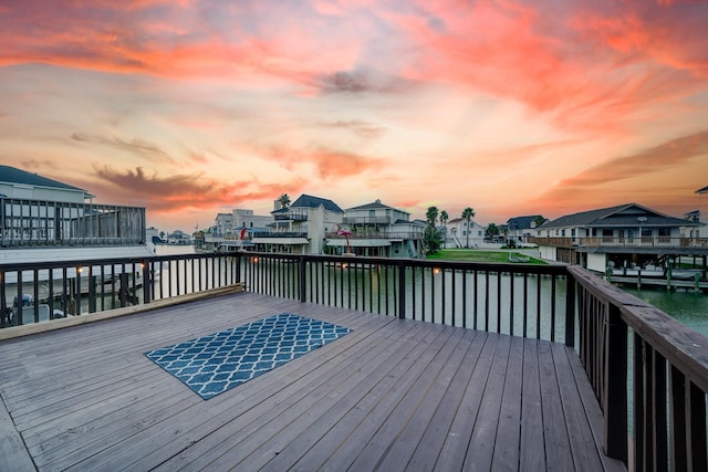 deck at dusk featuring a water view