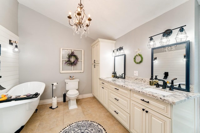 full bath featuring a freestanding bath, double vanity, vaulted ceiling, and a sink